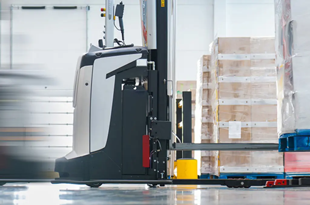 Un AGV transporta un palé en un almacén para la manipulación automatizada de materiales