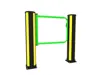 green safety gate for pedestrian impact protection mounted on black and yellow bollards