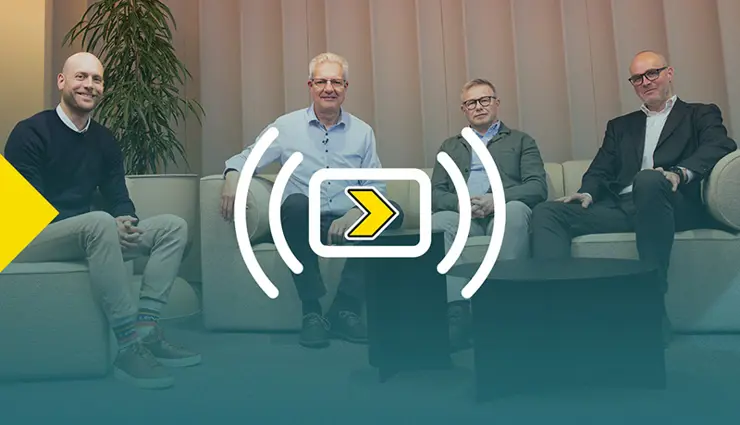 Four men seated on sofas facing the camera. The image has a gradient overlay with the logo for Axelent's webinar "Axelent Goes Live"