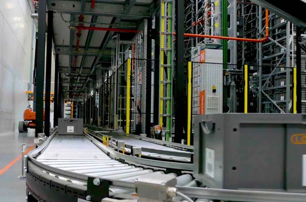 Equipo de clasificación automatizado en almacén con línea de transportadores y vallado de seguridad para una manipulación de materiales segura y eficiente