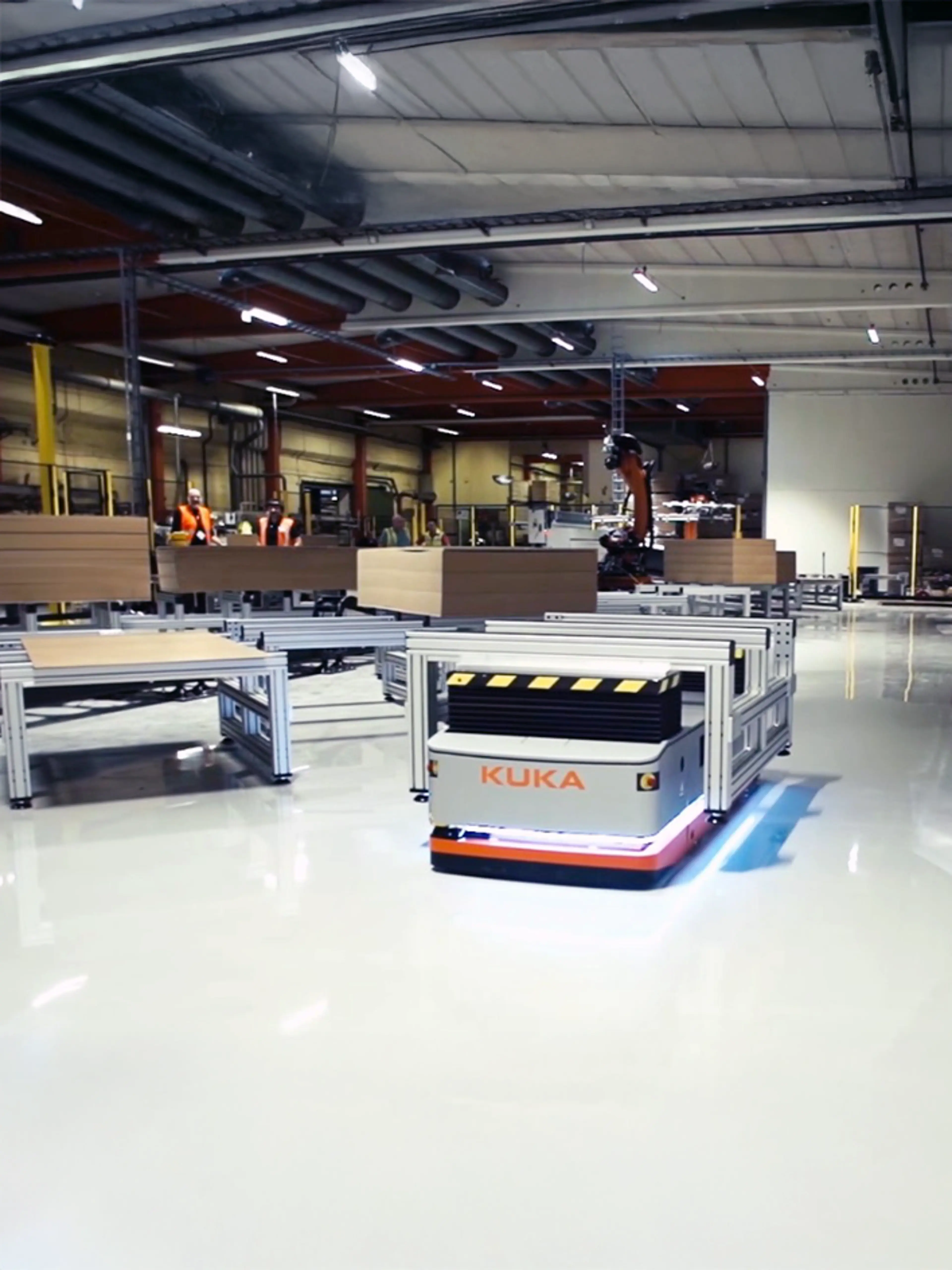 Robots móviles industriales operando en un almacén con barreras de seguridad que separan las zonas peatonales de los recorridos de los robots.