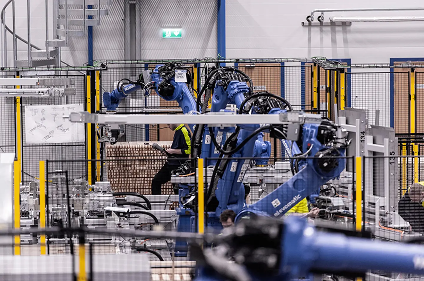 Brazos robóticos industriales paletizando mercancías dentro de una celda de automatización segura